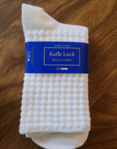 A pair of Katie Luck poodle socks with a blue label
