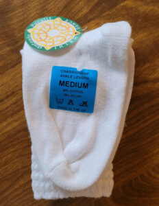 A pair of ankle length pacelli poodle socks with a blue sticker